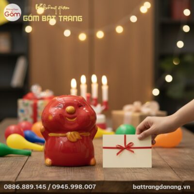 Cận cảnh heo đất gốm sứ Bát Tràng màu đỏ trên b...